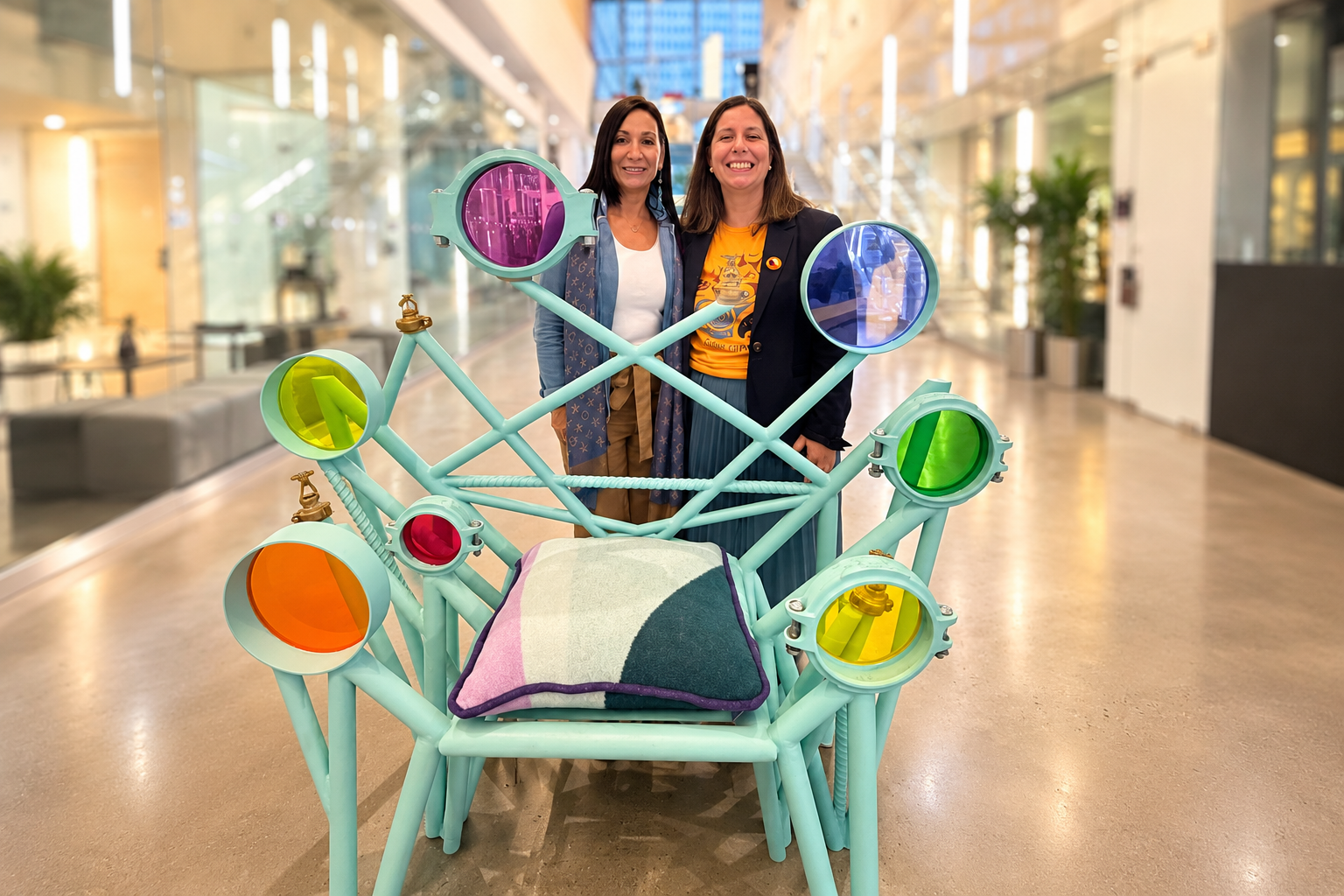 Two Women Behind a Colourful Sculptural Chair